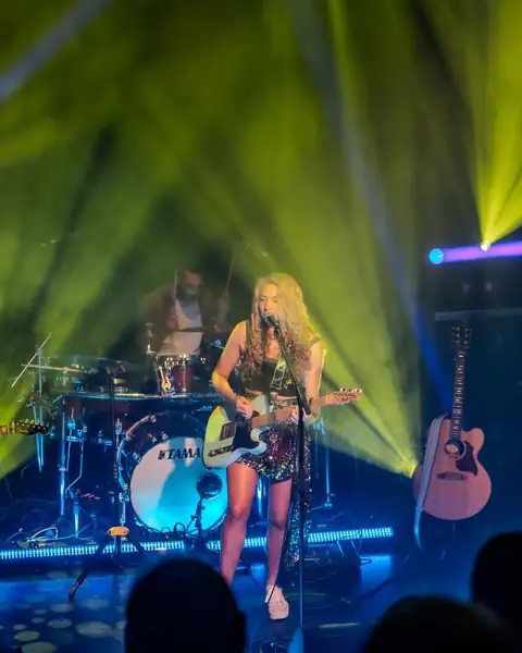 Maddison A on stage under green lights