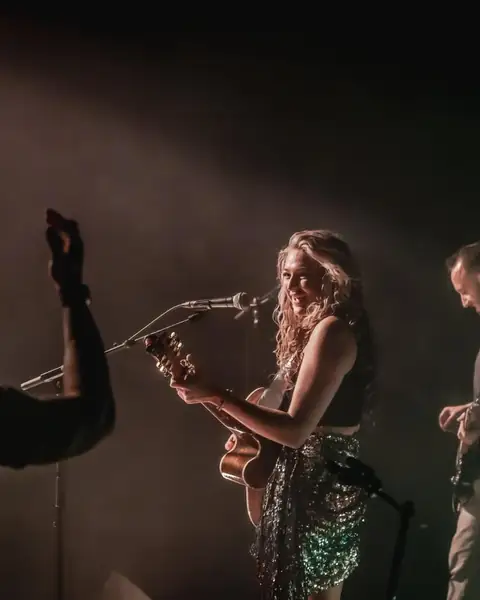 Maddison A on stage singing with her guitarist